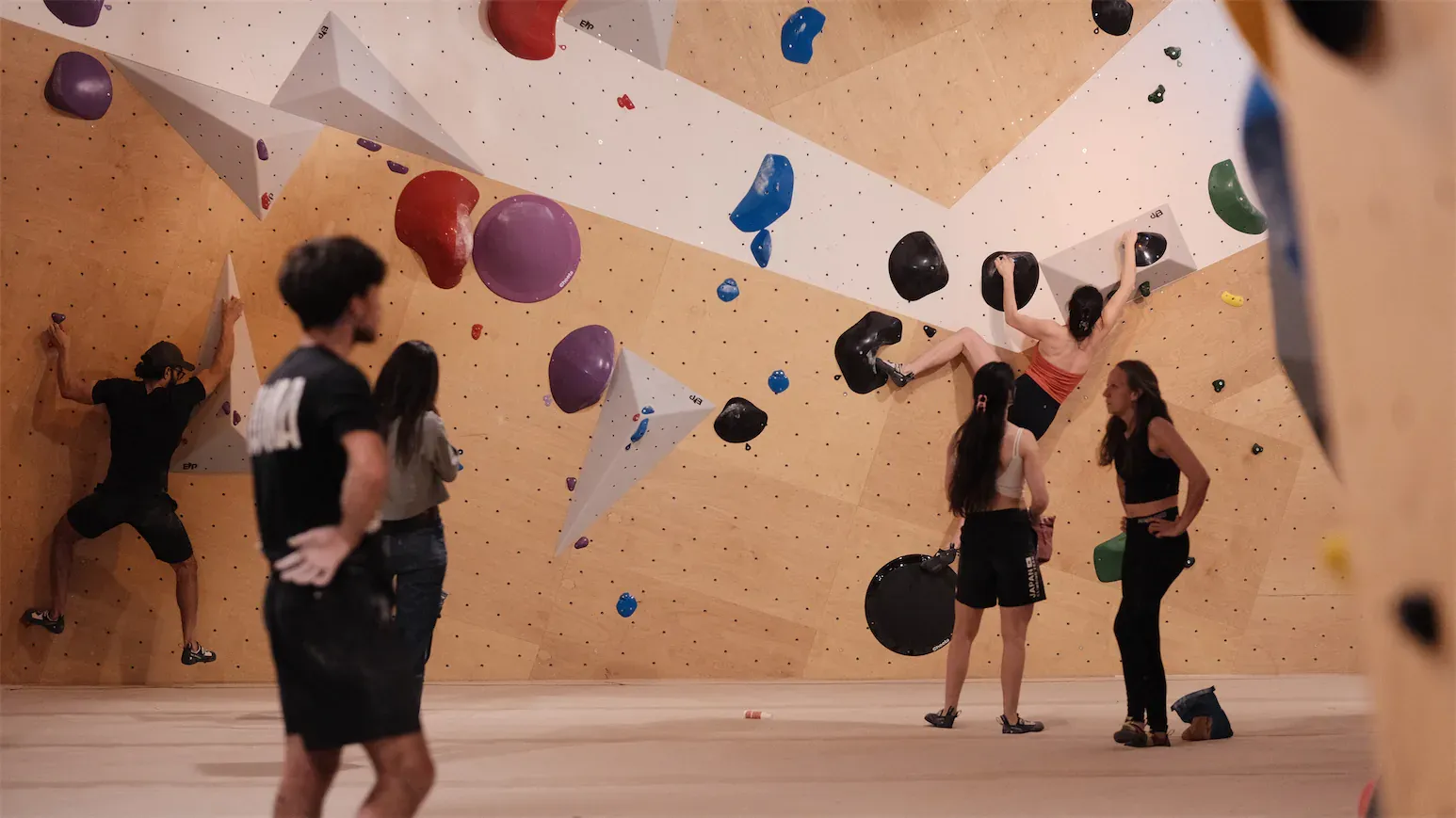 Session de groupe devant le mur d'escalade de bloc.